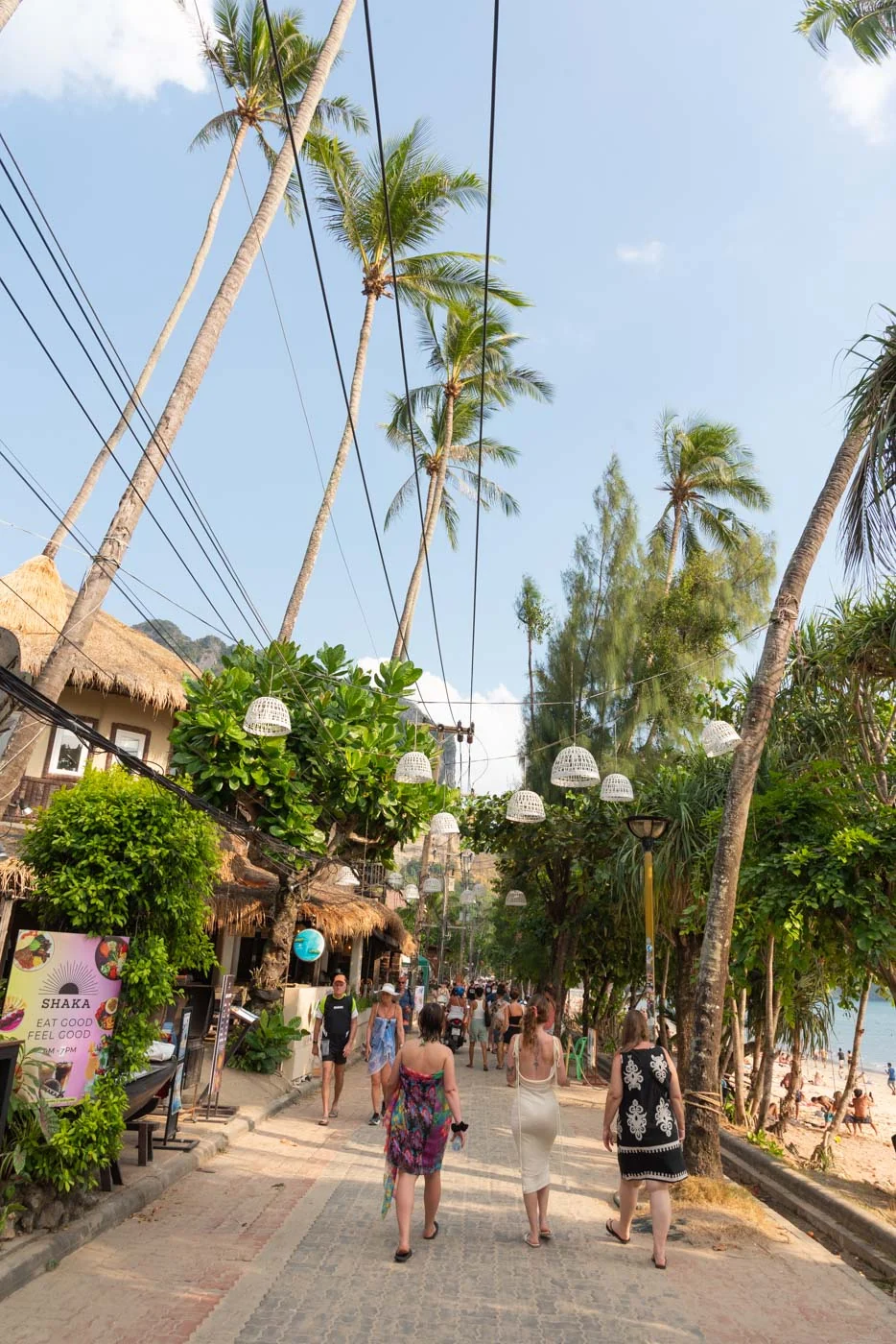 Promenade bordée de palmiers à Ao Nang, touristes marchant vers la plage