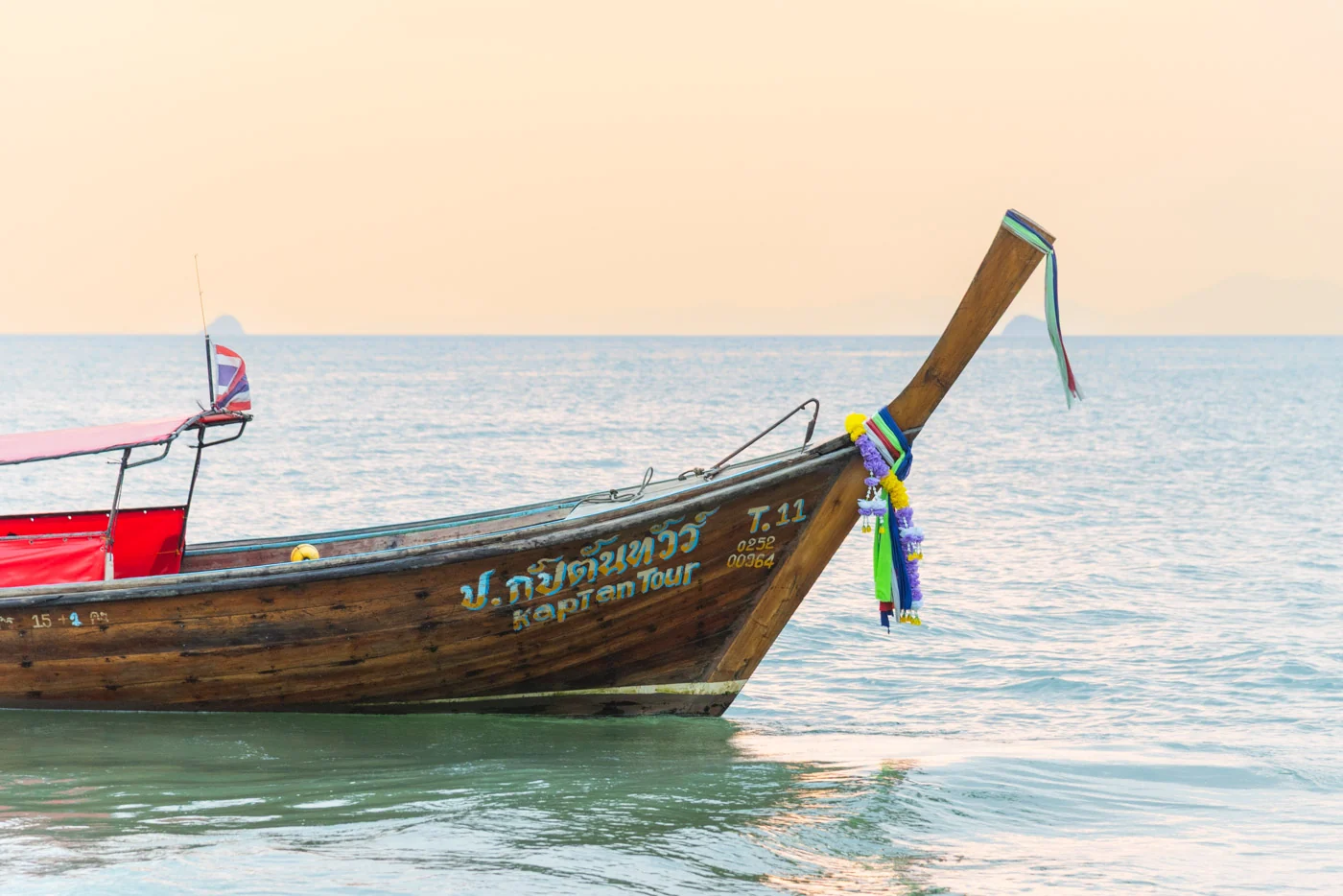 Bateau longtail décoré flottant sur l'eau calme de Klong Muang
