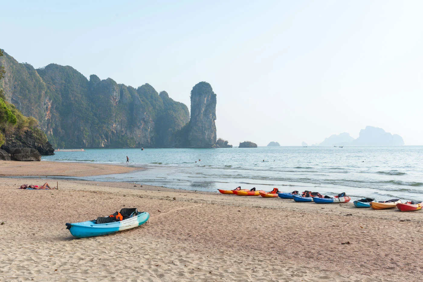 Kayaks colorés sur la plage de la province de Krabi, falaises majestueuses en arrière-plan