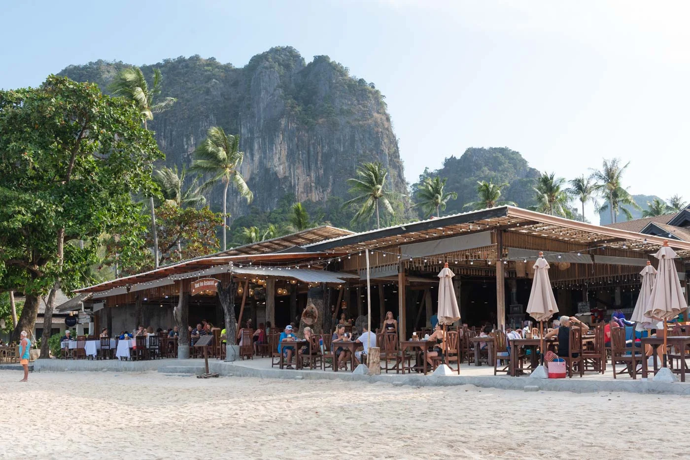 Restaurant en bord de mer à Railay Beach avec vue sur les falaises et palmiers
