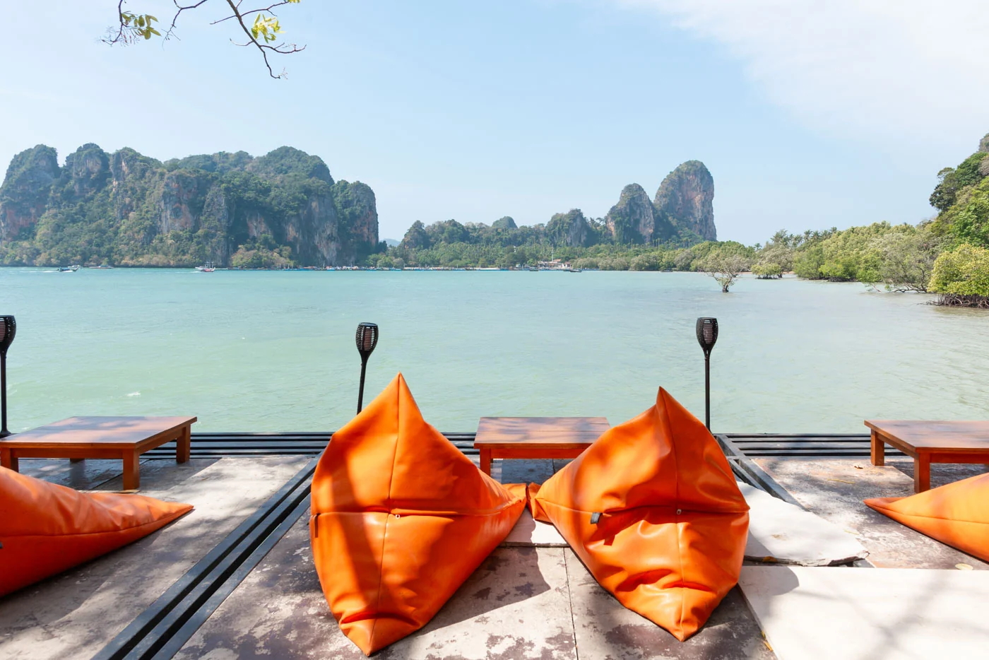 Terrasse avec poufs orange offrant vue sur la mer de Railay