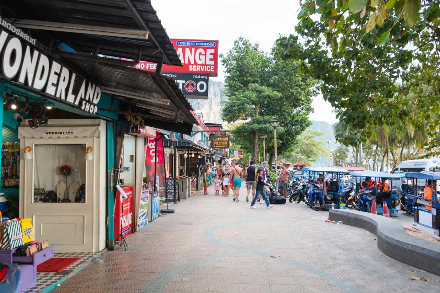 Rue commerçante animée à Ao Nang avec boutiques et touristes se promenant